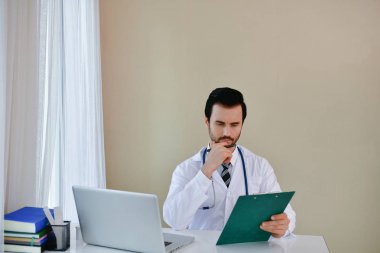 Ofiste poz doktor gülümseyen, o bir stetoskop giyiyor