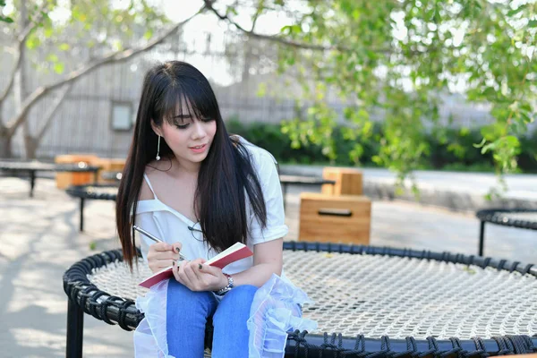 Conceitos de Educação. Mulheres asiáticas lendo livros no parque. Beaut... — Fotografia de Stock