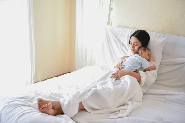 Концепция новорожденного. Мать и ребенок на белой кровати. Мама и ребенок Б — стоковое фото