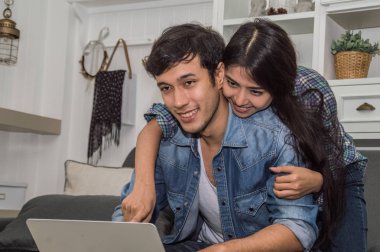 Oturma ro, mutlu duygu ile laptop ve kadın kullanan genç adam