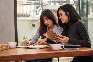 Güzel kız mutlu bir şekilde masanın üzerinde çalışıyor.