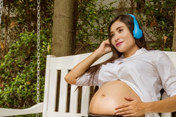 Těhotné ženy se poslouchat hudební melodie těší — Stock fotografie