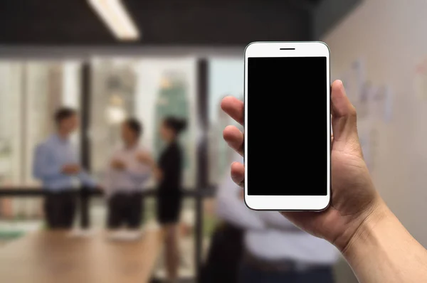 Тримайте мобільний телефон на фоні групи бізнесменів, які турбуються — стокове фото
