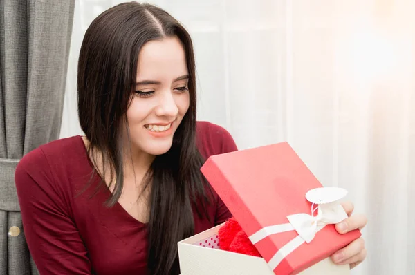 Joyeux jolie jeune femme tenant boîte cadeau dans la maison — Photo