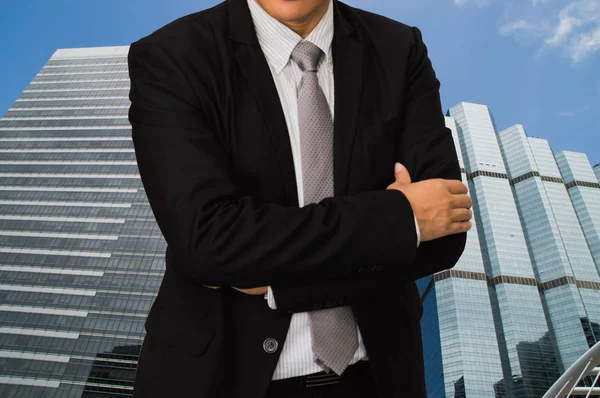 Joven hombre de negocios de pie en la parte posterior de un edificio en un negocio — Foto de Stock