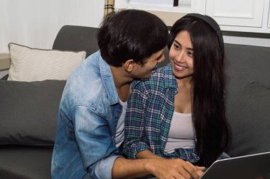 Oturma ro, mutlu duygu ile laptop ve kadın kullanan genç adam