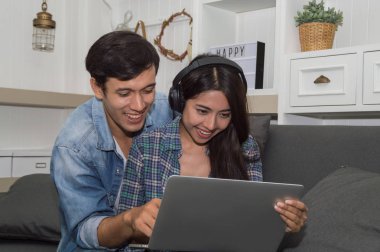 Oturma ro, mutlu duygu ile laptop ve kadın kullanan genç adam