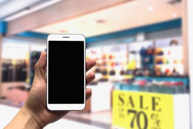 cep telefonu bulanık bir arka plan üzerinde tutan.