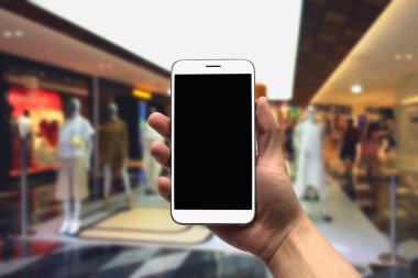 cep telefonu bulanık bir arka plan üzerinde tutan.