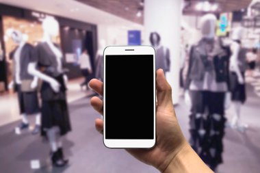 cep telefonu bulanık bir arka plan üzerinde tutan.