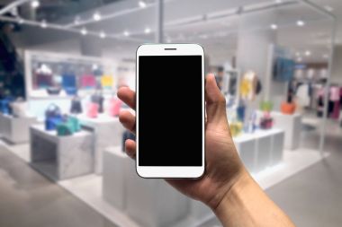 cep telefonu bulanık bir arka plan üzerinde tutan.