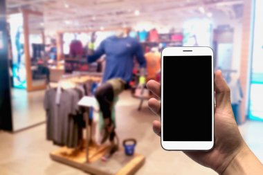 cep telefonu bulanık bir arka plan üzerinde tutan.