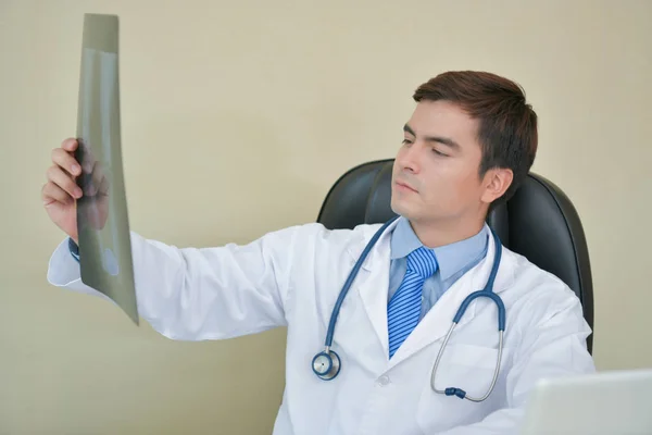 Улыбающийся доктор позирует в офисе, на нем стетоскоп. — стоковое фото