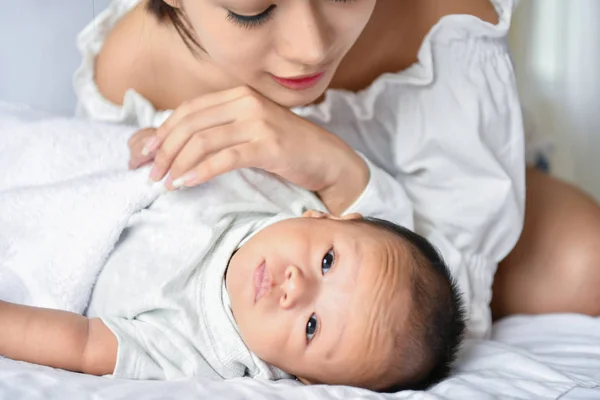 Concepto para recién nacidos. Madre e hijo en una cama blanca. Mamá y bebé b —  Fotos de Stock