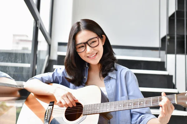 음악 개념입니다. 아시아 여자는 기타를 연주입니다. 아시아 여성 편안한 — 스톡 사진