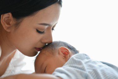 Yeni doğan kavramı. Anne ve çocuk beyaz bir yatakta. Anne ve bebek b
