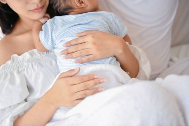 Yeni doğan kavramı. Anne ve çocuk beyaz bir yatakta. Anne ve bebek b