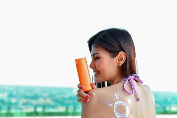 Conceito de fato de banho. Menina bonita em maiô está aplicando sunscre — Fotografia de Stock