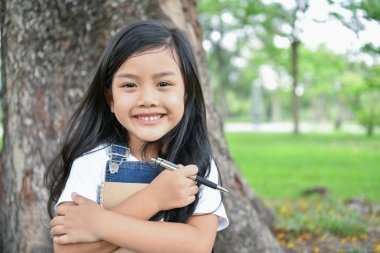 Eğitim kavramları. Kız bahçede bir kitap okuyor. Olmak