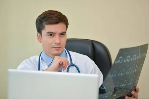 Médico sonriente posando en la oficina, lleva un estetoscopio — Foto de Stock