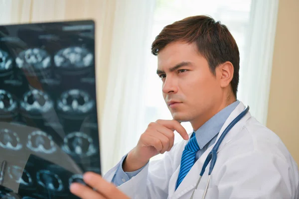 stock image Smiling doctor posing in the office, he is wearing a stethoscope