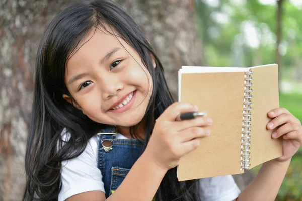 Concepts éducatifs. La fille lit un livre dans le jardin. Sois — Photo