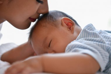 Yeni doğan kavramı. Anne ve çocuk beyaz bir yatakta. Anne ve bebek b