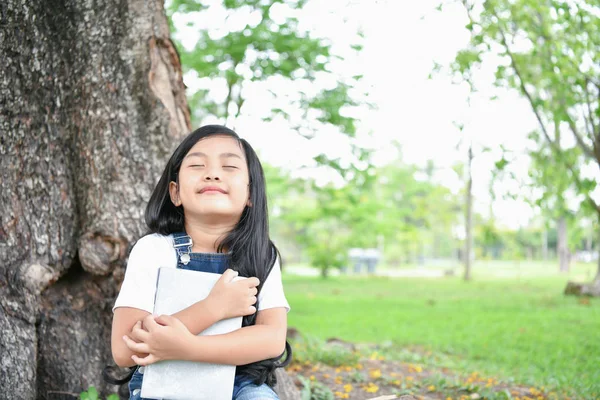 Conceitos de Educação. A rapariga está a ler um livro no jardim. Seja — Fotografia de Stock