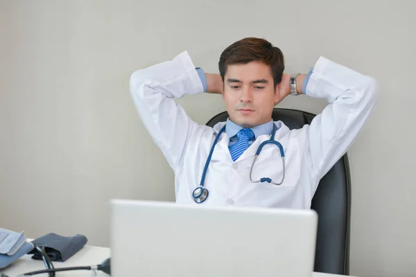 Docteur souriant posant dans le bureau, il porte un stéthoscope — Photo