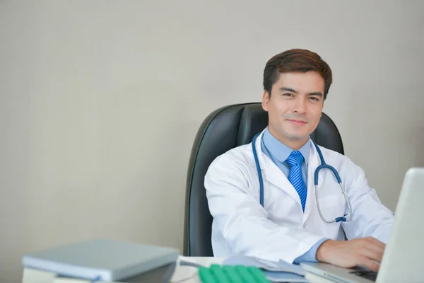 Smiling doctor posing in the office, he is wearing a stethoscope