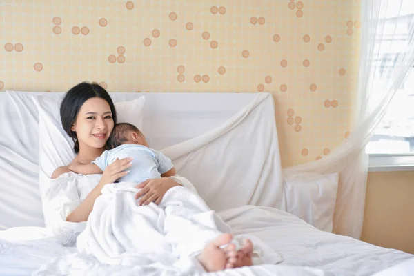 Концепция новорожденного. Мать и ребенок на белой кровати. Мама и ребенок Б — стоковое фото