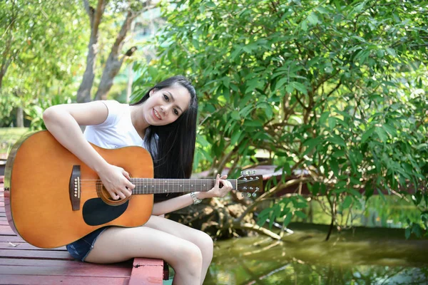 Conceptos musicales. Chicas asiáticas tocando la guitarra. Mujeres asiáticas relajantes —  Fotos de Stock