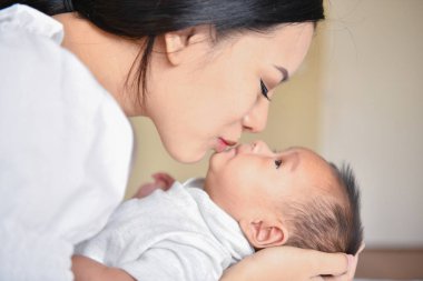 Yeni doğan kavramı. Anne ve çocuk beyaz bir yatakta. Anne ve bebek b
