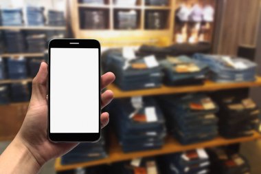 cep telefonu bulanık bir arka plan üzerinde tutan.