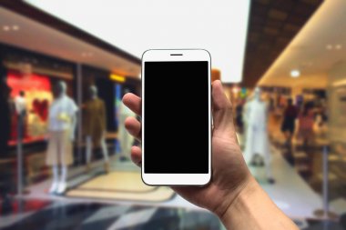 cep telefonu bulanık bir arka plan üzerinde tutan.