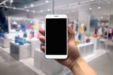 cep telefonu bulanık bir arka plan üzerinde tutan.