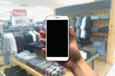 cep telefonu bulanık bir arka plan üzerinde tutan.