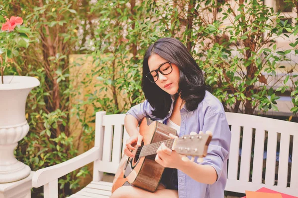 음악 개념입니다. 아시아 여자는 기타를 연주입니다. 아시아 여성 편안한 — 스톡 사진