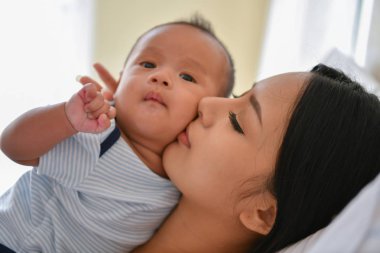 Yeni doğan kavramı. Anne ve çocuk beyaz bir yatakta. Anne ve bebek b