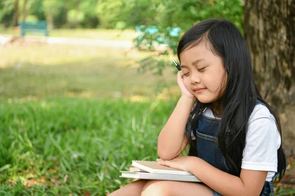Conceptos educativos. La chica está leyendo un libro en el jardín. Sé Fotos De Stock