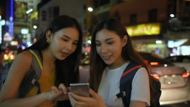 Cestovní koncept. Mladé ženy otevírají mobilní telefony, aby hledaly cestovní informace. Rozlišení 4k.
