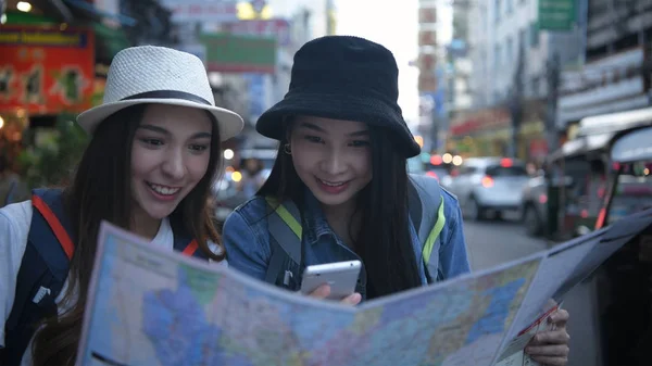 Concetto di viaggio. Belle ragazze stanno leggendo la mappa sulle strade — Foto Stock