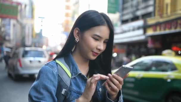 旅行のコンセプト 美しい女性が喜んで市内で携帯電話を果たしている 4K分解能 — ストック動画