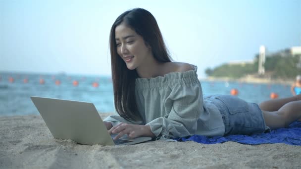 休日の概念 美しい女性がビーチでノートと一緒に働いています 4K分解能 — ストック動画