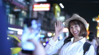 Seyahat konsepti. Genç bayan turistler şehirde fotoğraf çektirip oynuyorlar. 4k Çözünürlüğü.