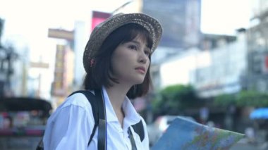 Turizm konsepti. Turistler kentteki haritaya bakarak mutlu bir şekilde duruyorlar. 4k Çözünürlüğü.