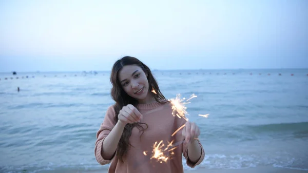 Conceito de férias. Meninas asiáticas jogando fogos de artifício divertidos na praia . — Fotografia de Stock