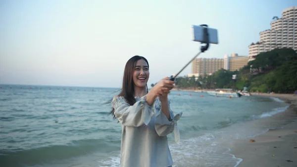 Travel concept. Beautiful girl calling video on mobile to the be — Stock Photo, Image