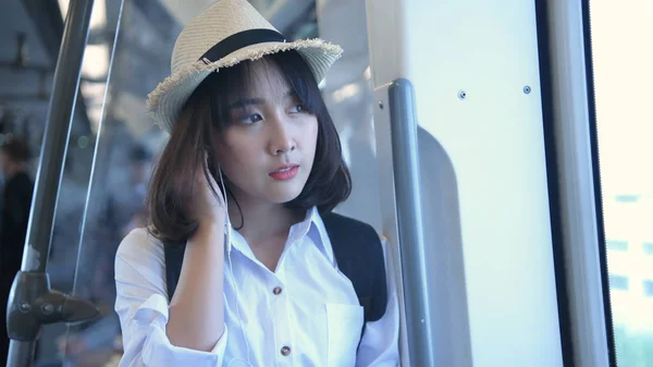 一个漂亮的女人插在火车上的耳机里. 4k Reso — 图库照片