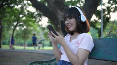 Tatil konsepti. Asyalı kız tuvalette müzik dinlemekten zevk alıyor.